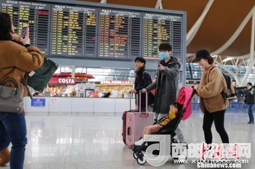 旅客帶著孩子前往辦票柜臺(tái)辦理登機(jī)手續(xù)?！∫罅⑶?攝