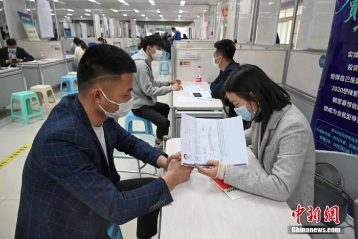 4月14日，招聘者在查看求職者簡(jiǎn)歷。<a target='_blank'  data-cke-saved- >中新社</a>記者 王剛 攝
