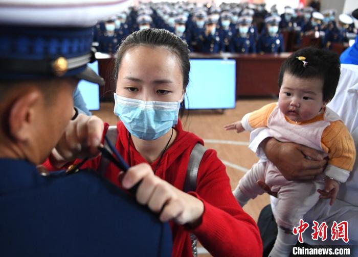 新消防員楊振的妻子彭莉與女兒現(xiàn)場(chǎng)見證丈夫加入“火焰藍(lán)”的神圣時(shí)刻?！⒅铱?攝