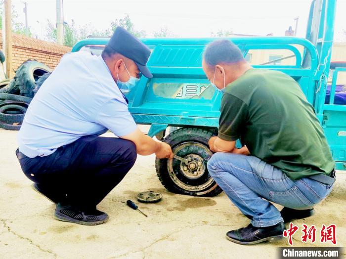 賽旦與民警共同維修三輪摩托車?！∫懒窘?攝