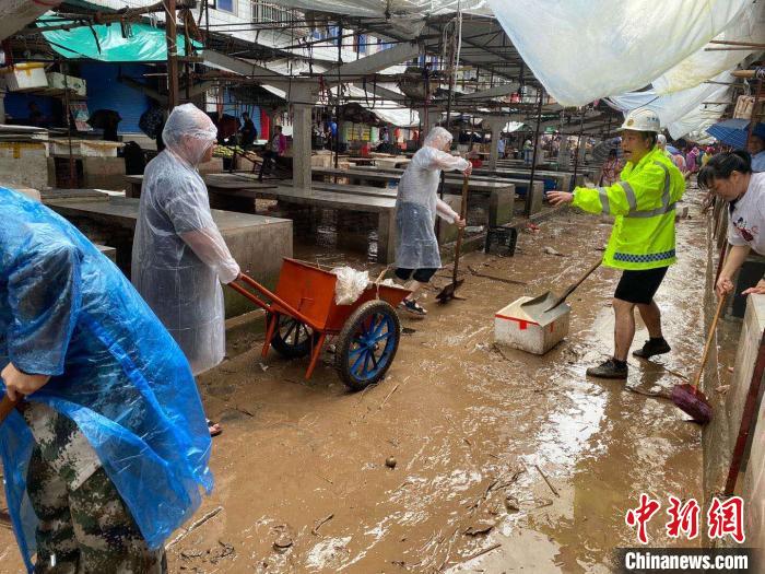 圖為7月26日，暴雨引發(fā)的洪水過境后，重慶萬州區(qū)分水鎮(zhèn)政府干部職工及志愿者清掃淤泥和垃圾?！　≈貞c萬州區(qū)委宣傳部供圖 攝