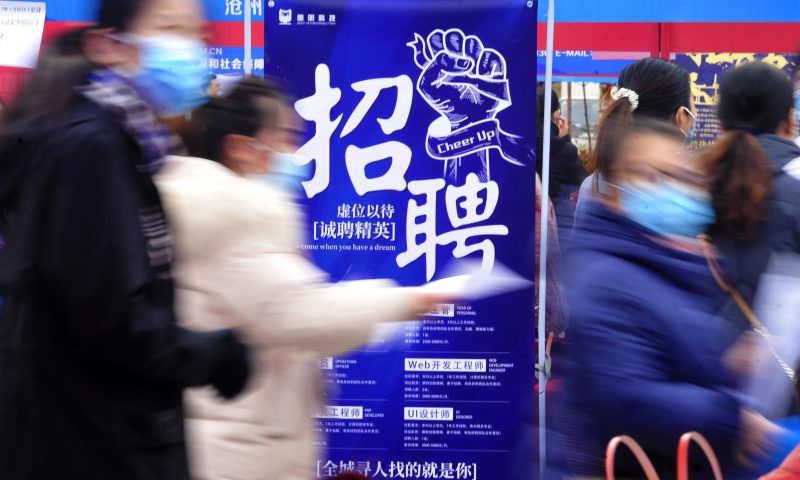 求職者從一家招聘企業(yè)的廣告牌前走過。新華社發(fā)（苑立偉 攝）
